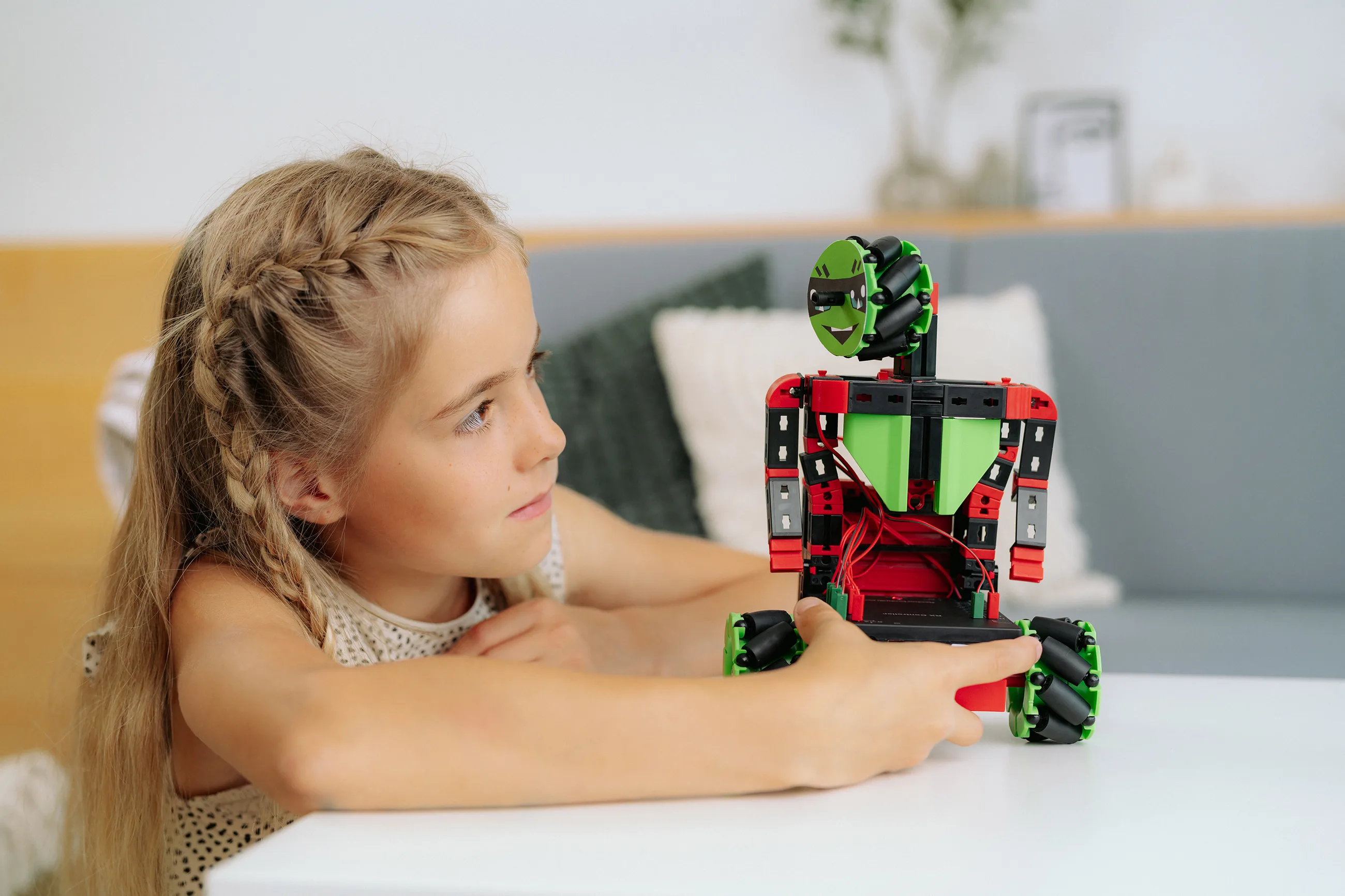 Niña interactuando con un robot educativo Fischertechnik